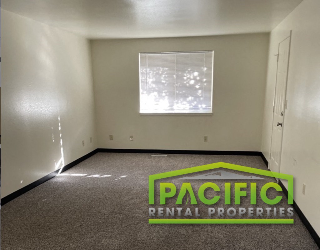 an empty room with a pacific rental properties logo on the floor