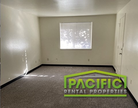 an empty room with a pacific rental properties logo on the floor