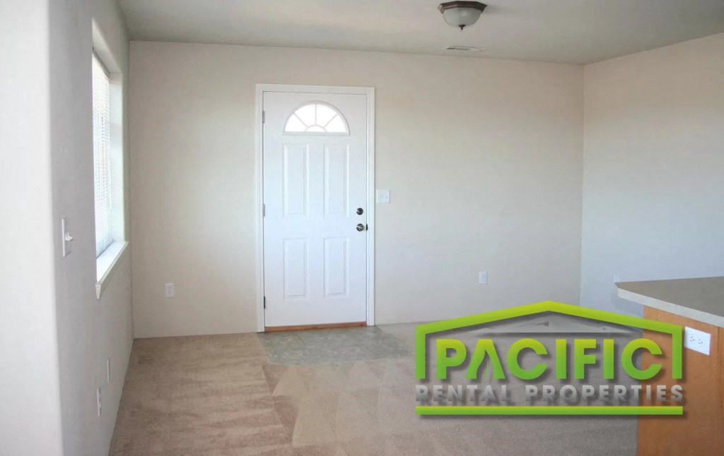 a living room with a white door and a tile floor