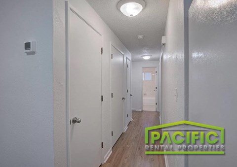 A hallway with doors on both sides and a logo in the middle.