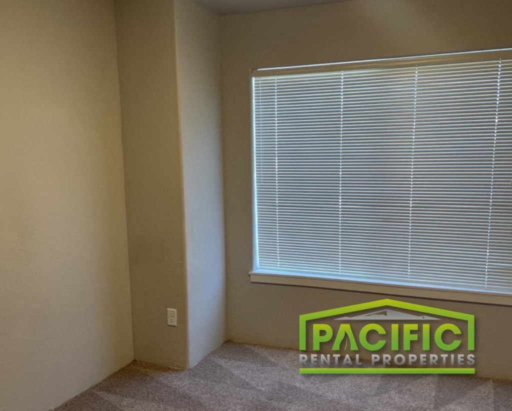 an empty room with a window and a pacific dental properties logo on the floor