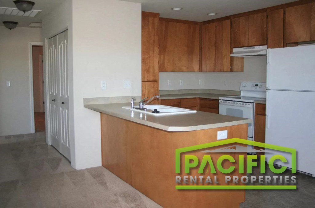 an empty kitchen with wooden cabinets and a sink
