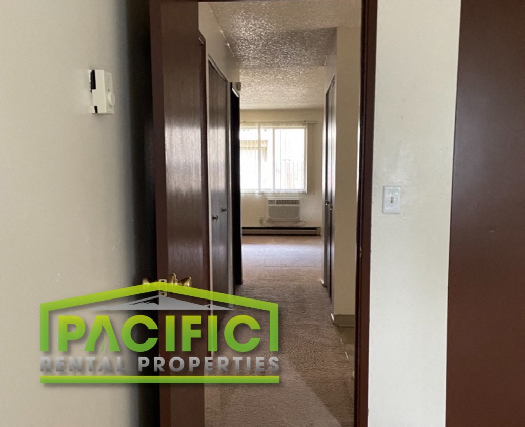 an empty apartment with a pacific rental properties logo on the door