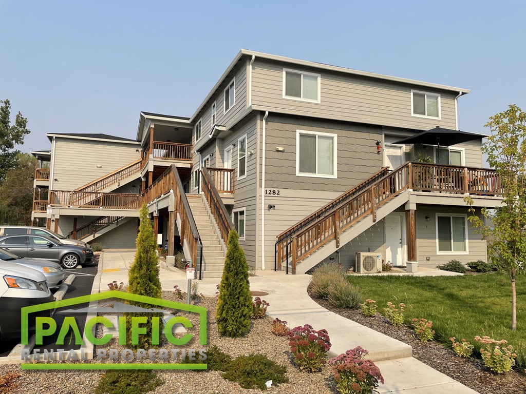 a home with stairs and a yard with a sidewalk