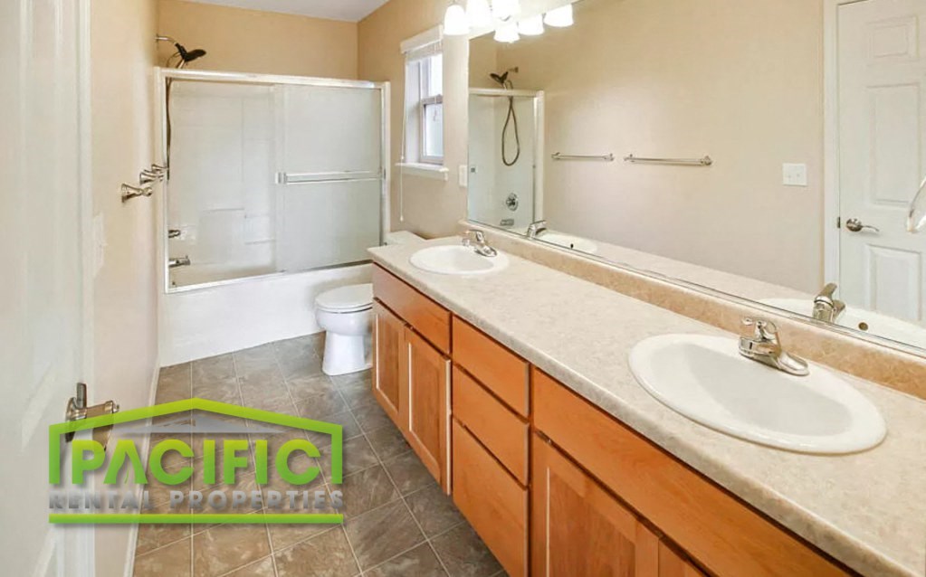 a bathroom with two sinks and a toilet