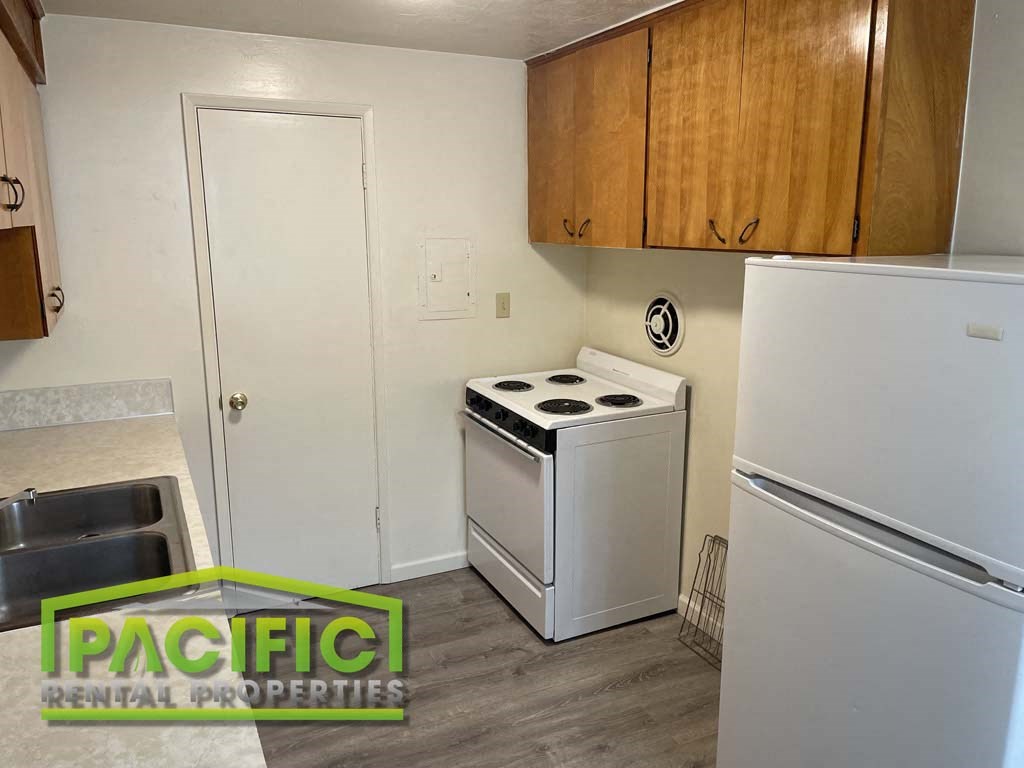 a small kitchen with a white stove and refrigerator