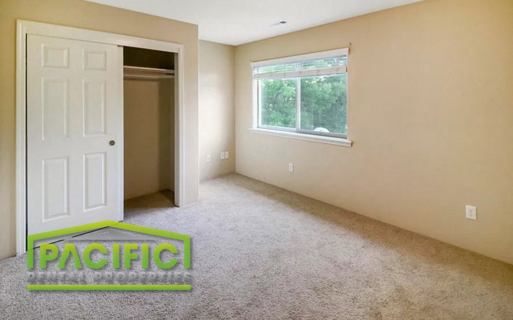 a empty room with a white door and a window