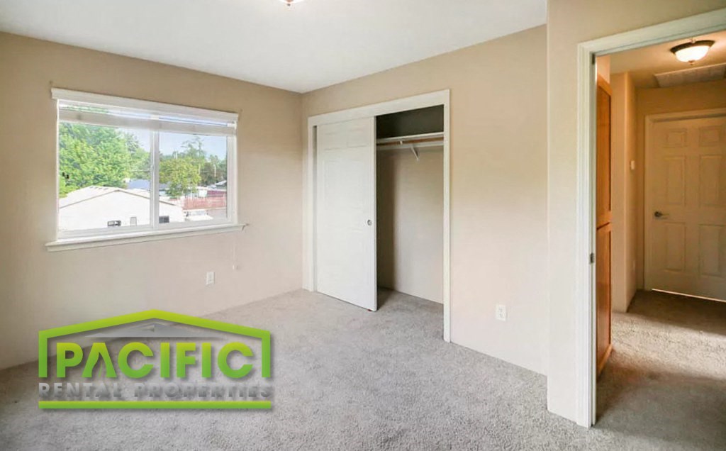 an empty bedroom with a closet and a window
