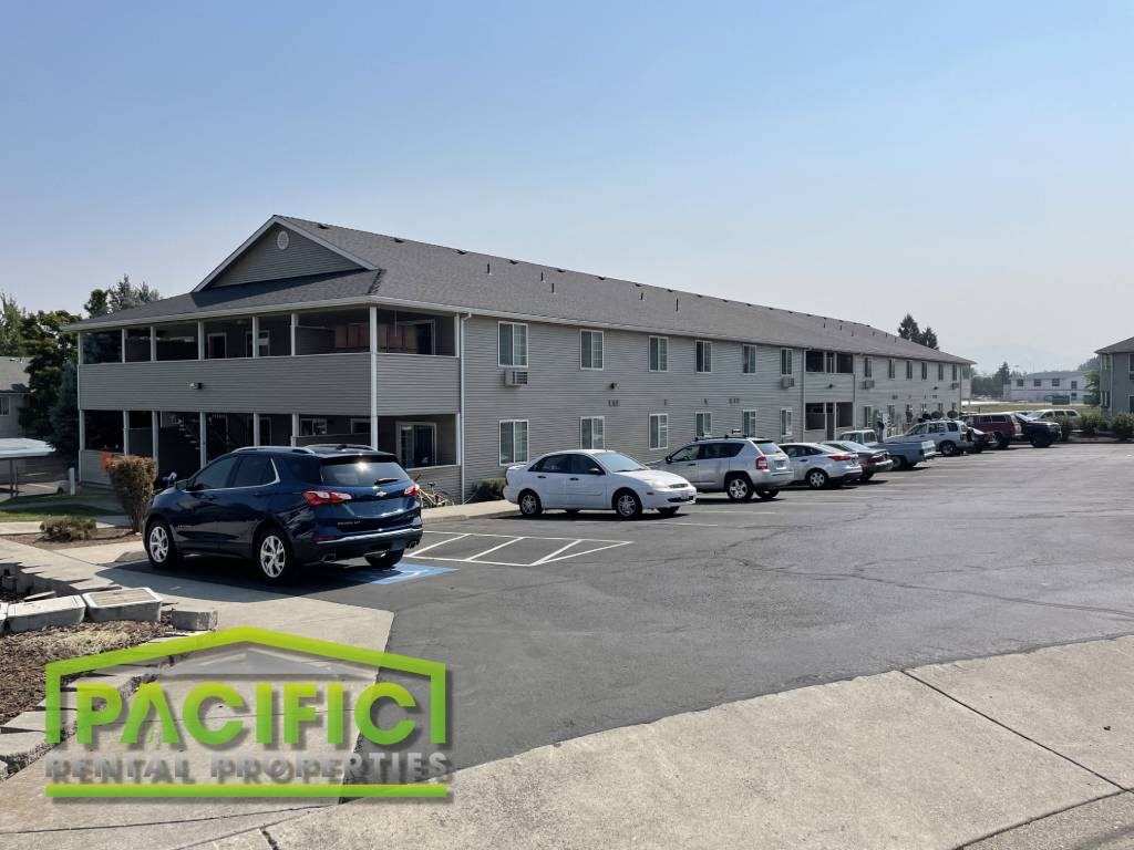 a parking lot with cars in front of a building