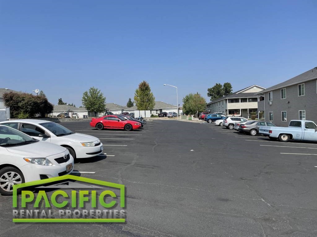 a parking lot filled with cars in front of apartment buildings
