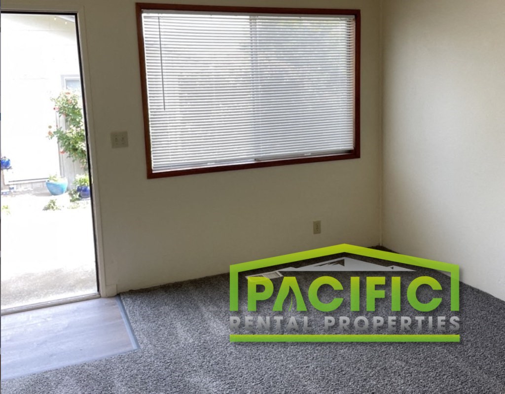 an empty room with a pacific commercial properties sign on the floor