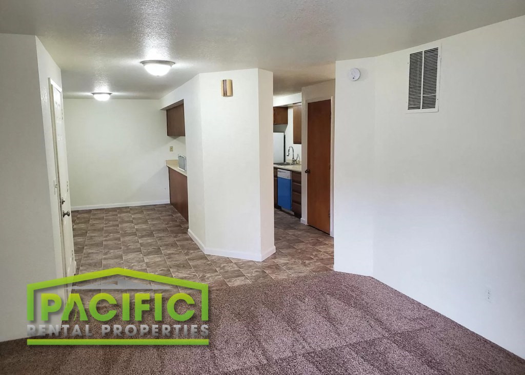 the living room and kitchen of an empty apartment