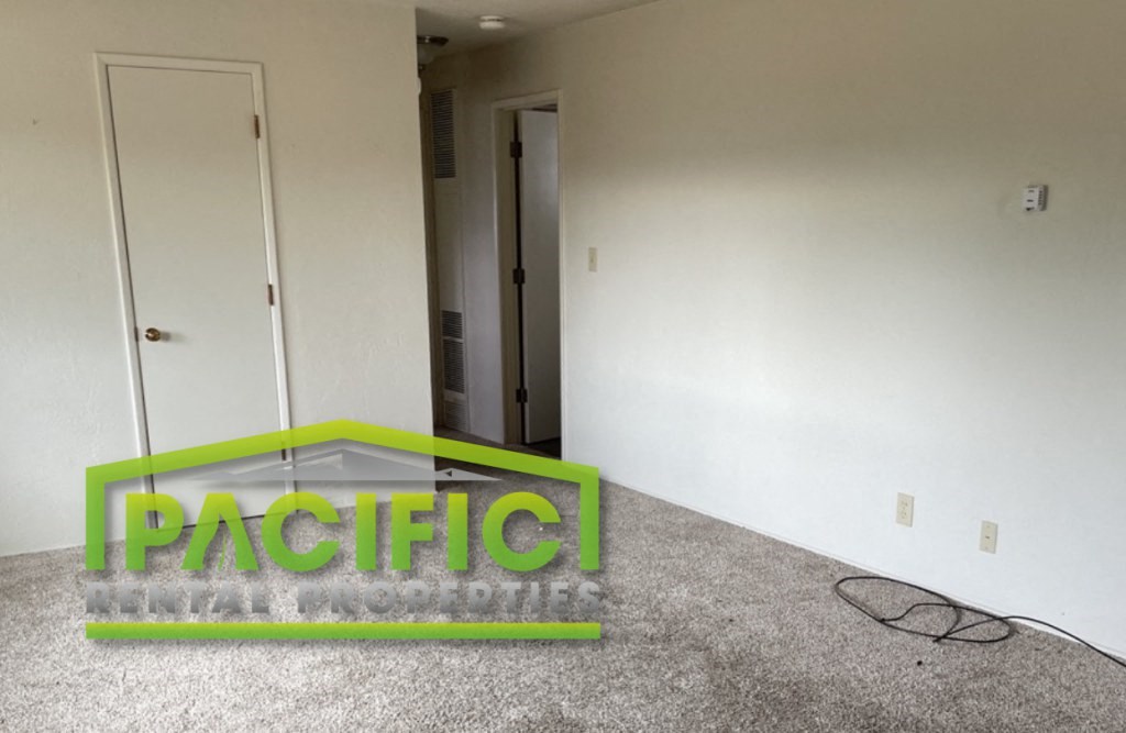 an empty room with a green neon sign on the floor