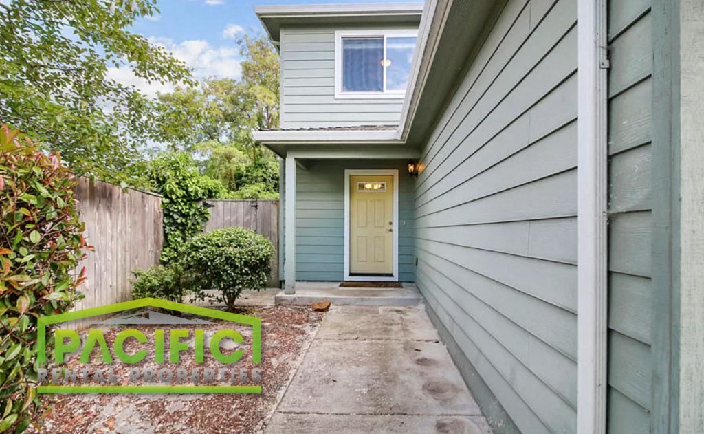 a blue house with a yellow door and a sidewalk