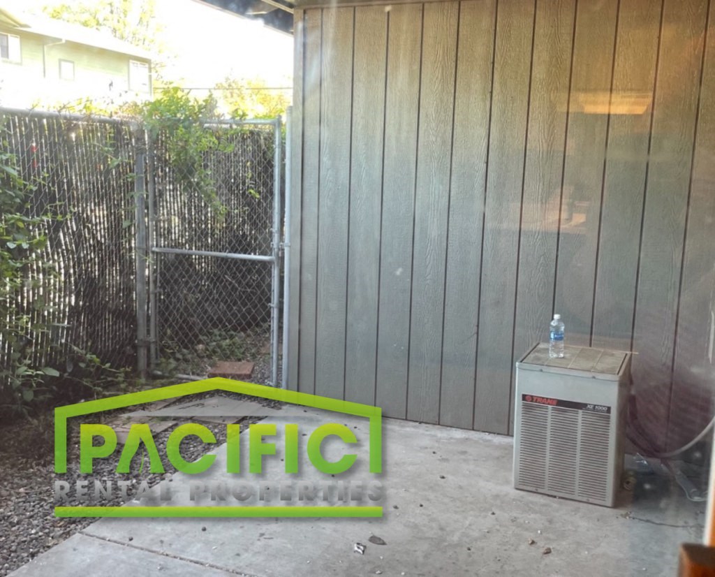 the side of a house with a radiator and a sign on the ground