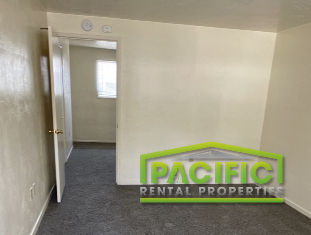 a corridor with a pacific rental properties logo on the wall