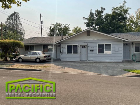 a white house with a car parked in front of it