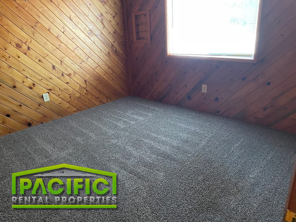 the inside of a small room with carpet and a logo on the floor