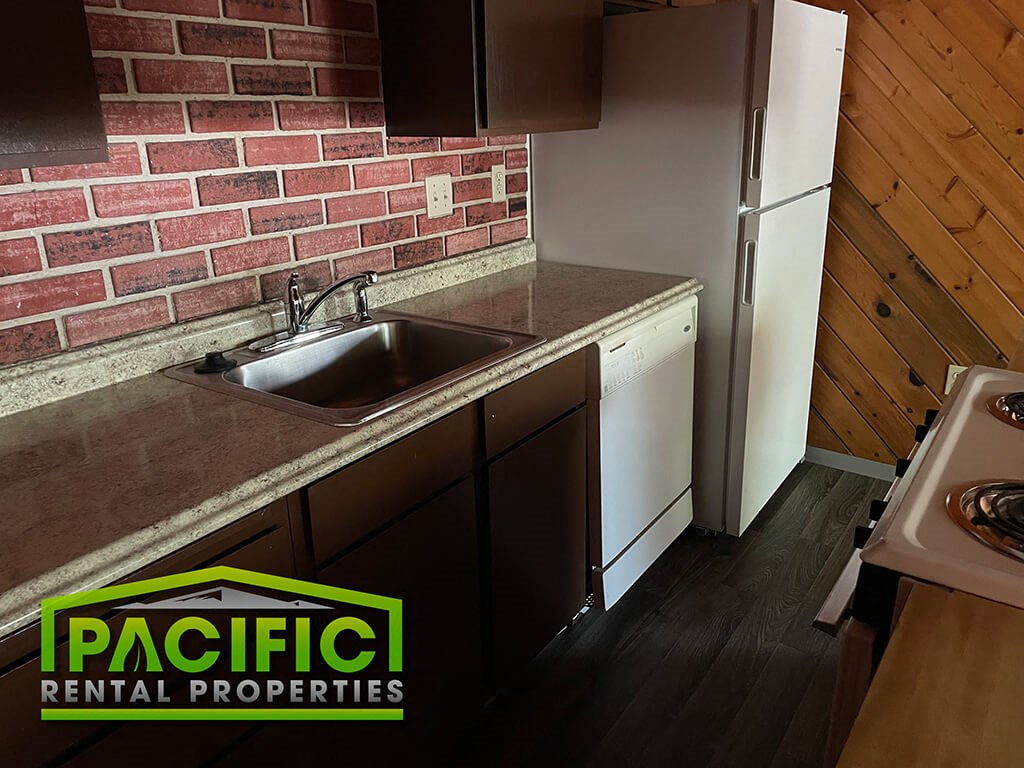 a kitchen with a sink and a brick wall