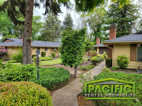 a neighborhood of bungalows with trees and a sidewalk