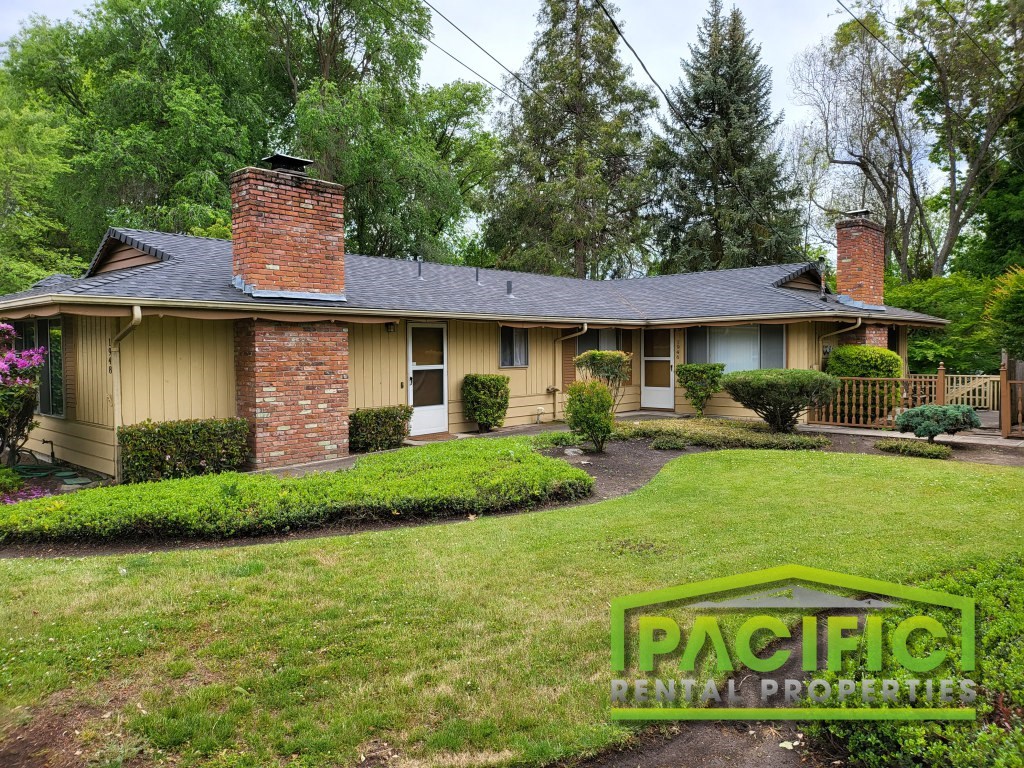 a yellow house with a brick chimney on the front