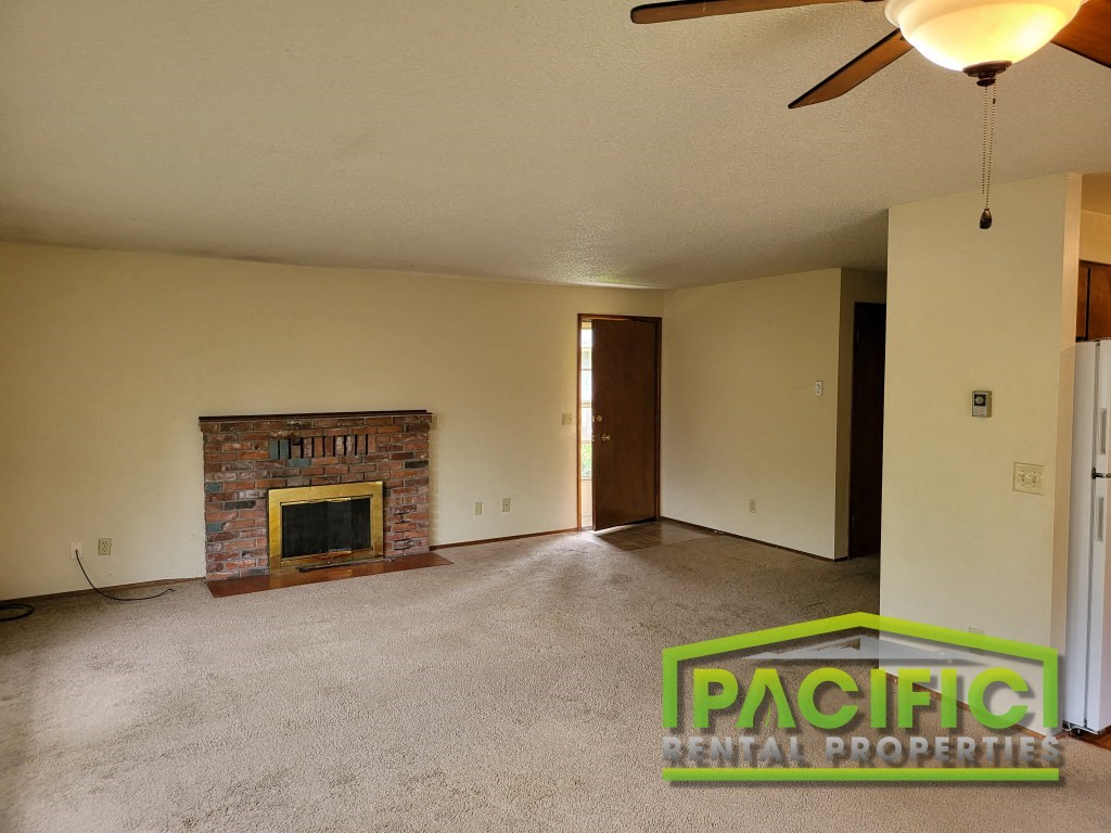 the living room of an empty house with a fireplace