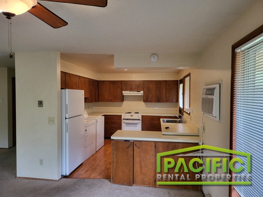 a kitchen with white appliances and wooden cabinets
