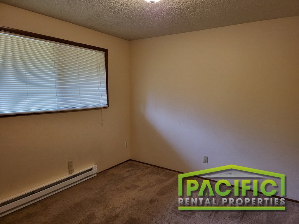 the living room of an empty room with a large window