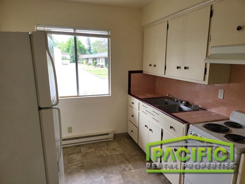 a kitchen with white cabinets and a sink and a refrigerator