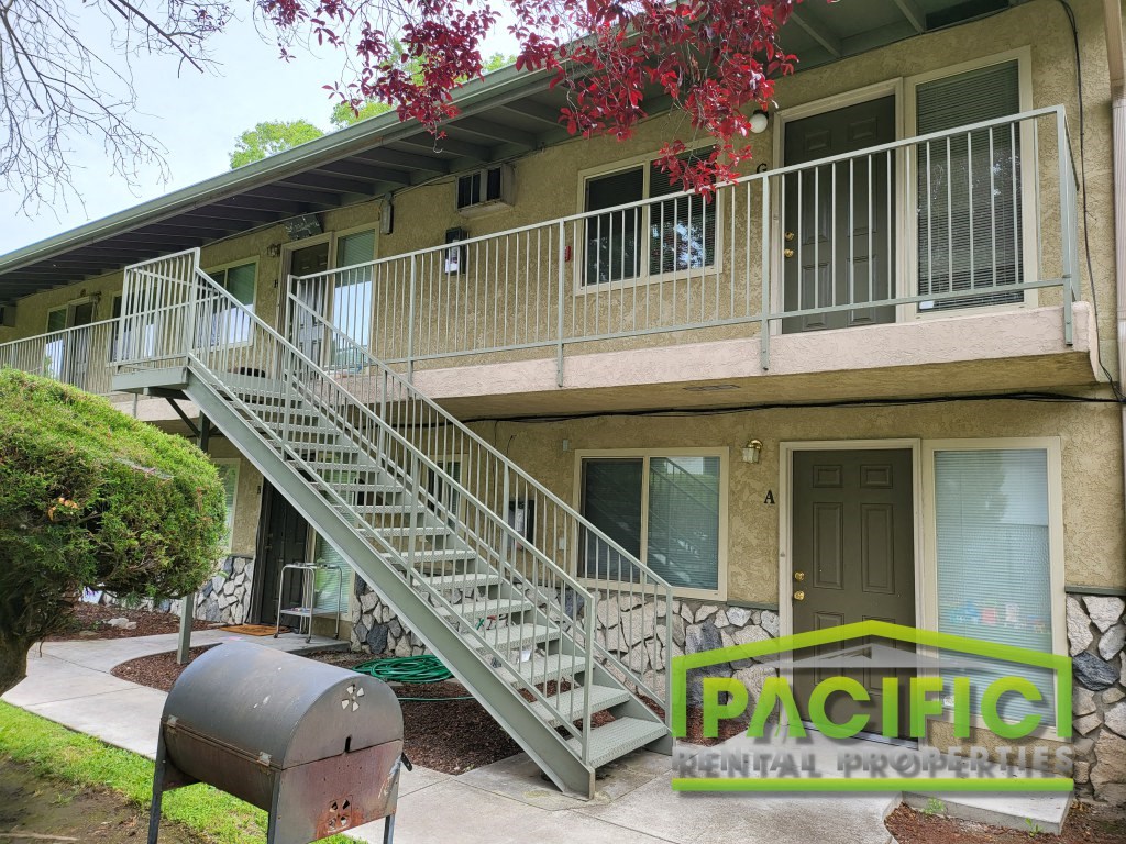 an image of a residential building with stairs and a grill