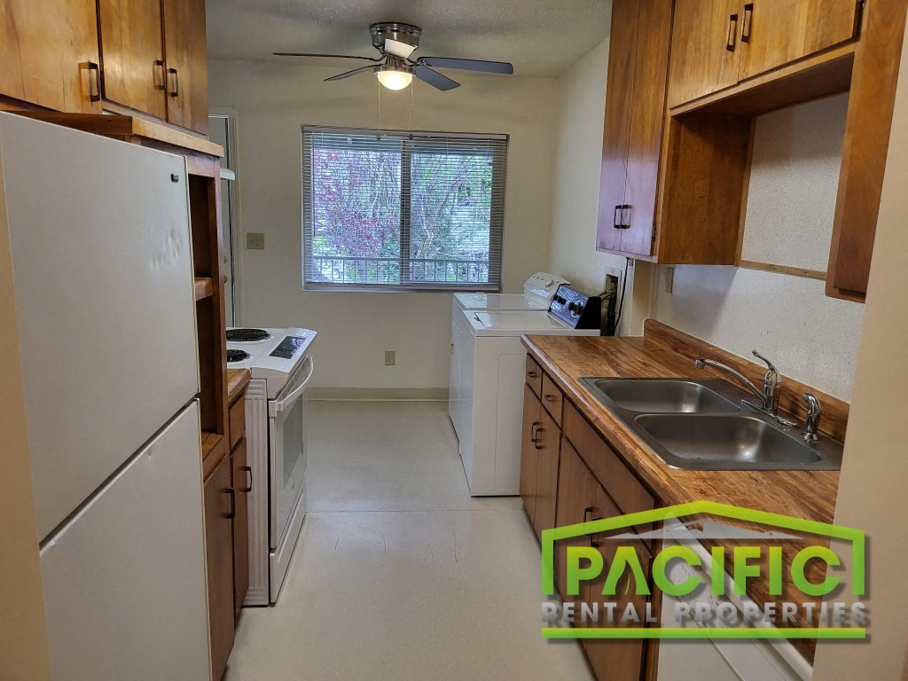 a small kitchen with white appliances and wooden cabinets