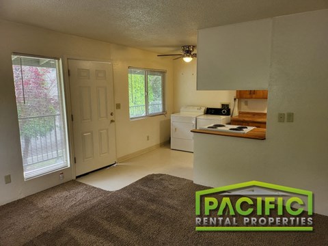 the interior of an empty living room with a kitchen