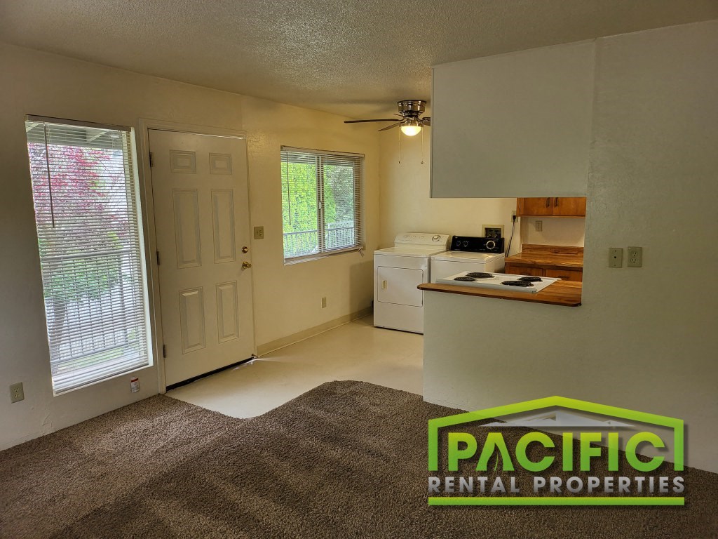 the interior of an empty living room with a kitchen