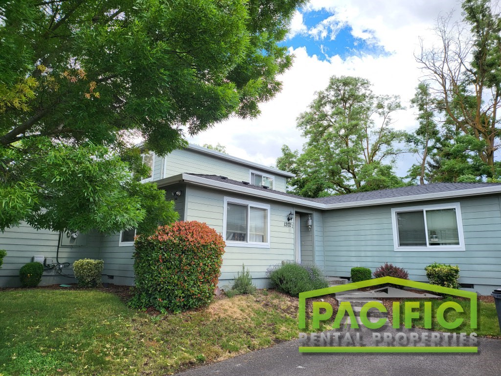 a blue house with a pacific rental properties sign in front