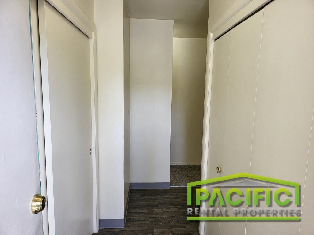 a row of white closets in a room with a wooden floor