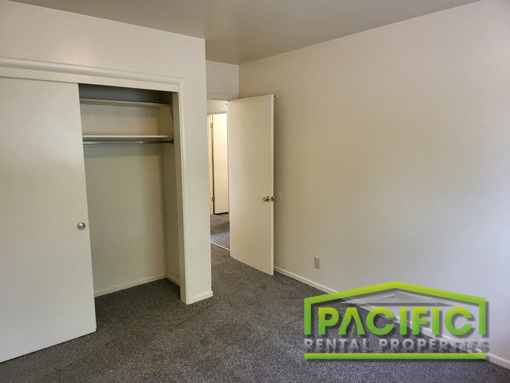 a bedroom with a closet and a mirrored closet door
