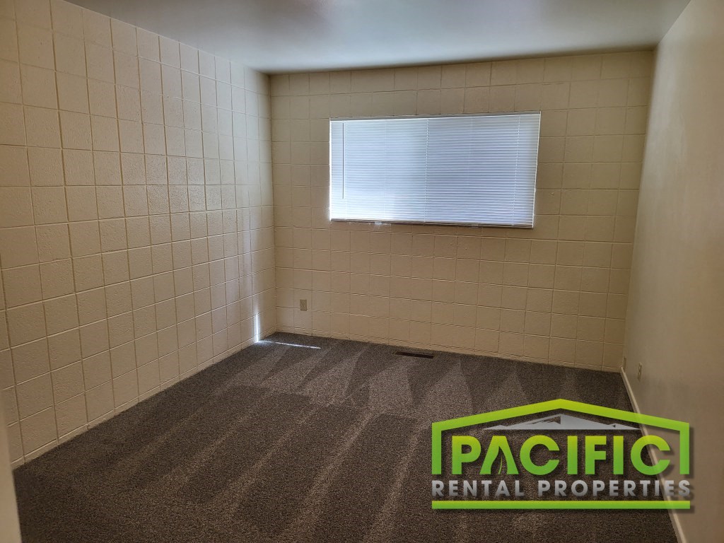 a small room with a window and a carpeted floor