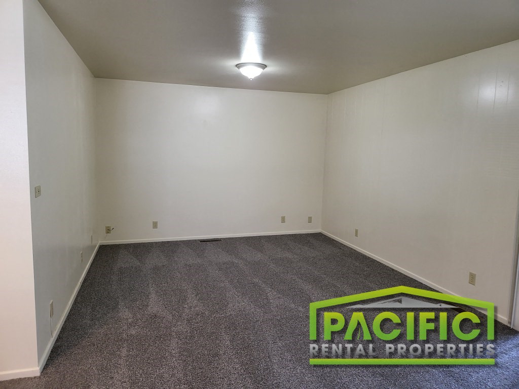 a empty room with a carpeted floor and a light on the ceiling