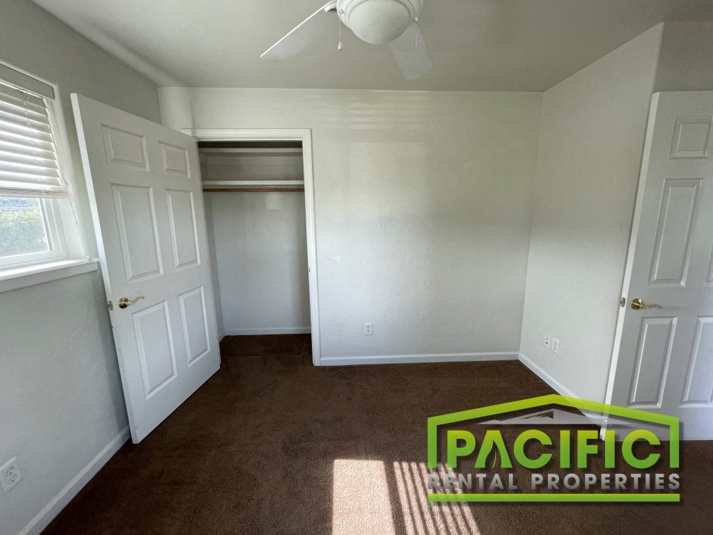 a empty room with a closet and a ceiling fan