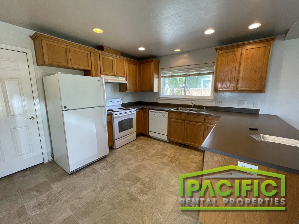 a kitchen with white appliances and wooden cabinets