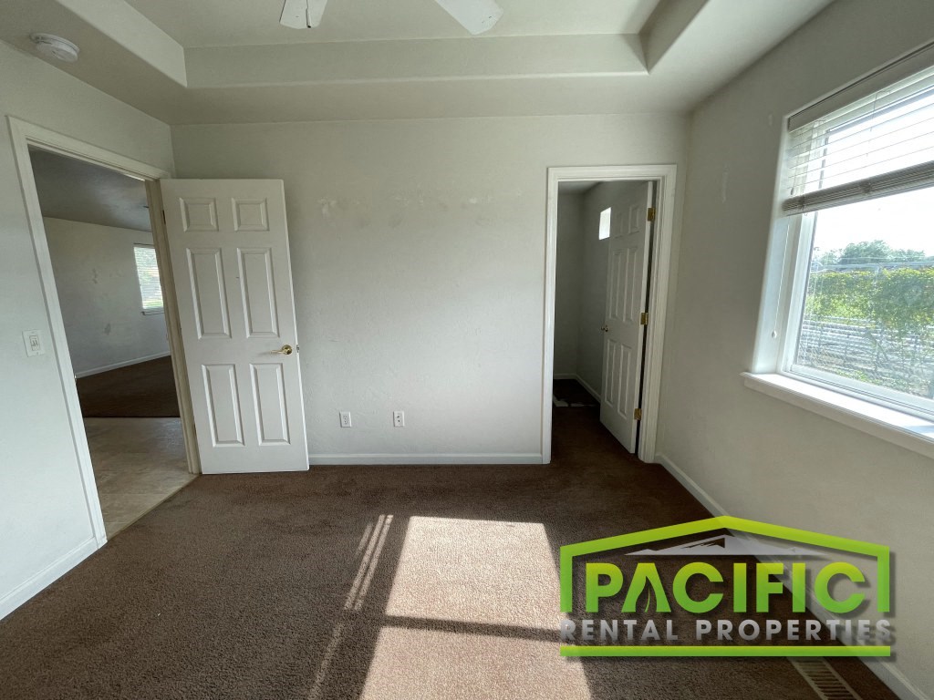 an empty room with a door and a carpeted floor