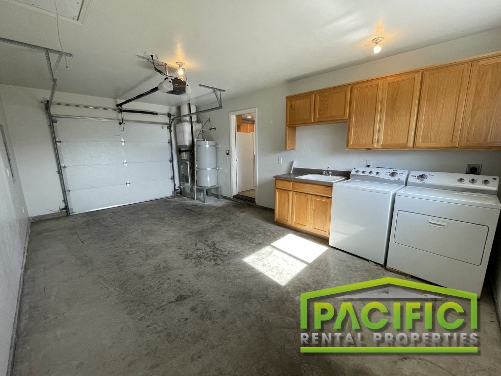an empty kitchen with white appliances and wood cabinets