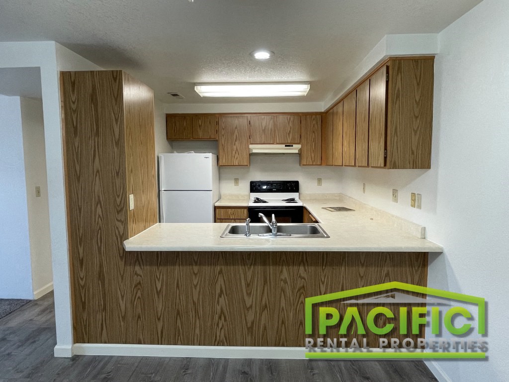 a renovated kitchen with wooden cabinets and a white counter top