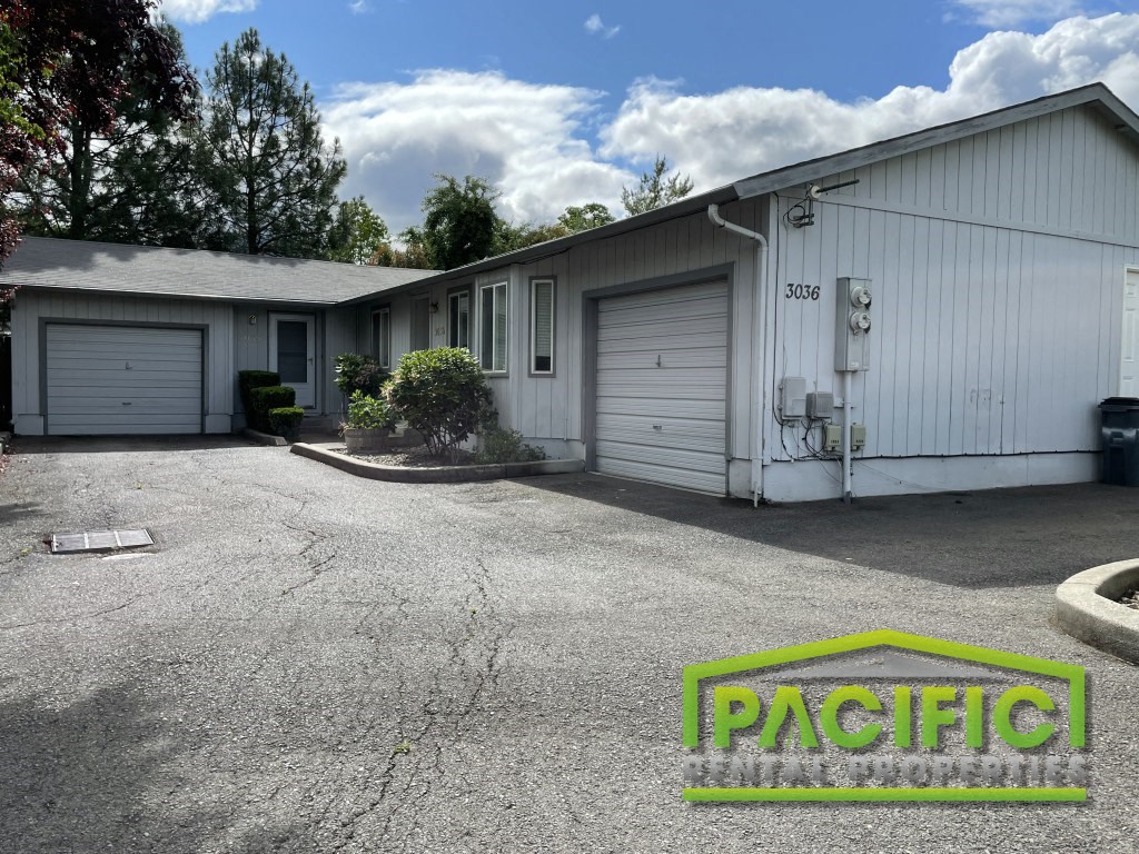 a parking lot in front of a white building