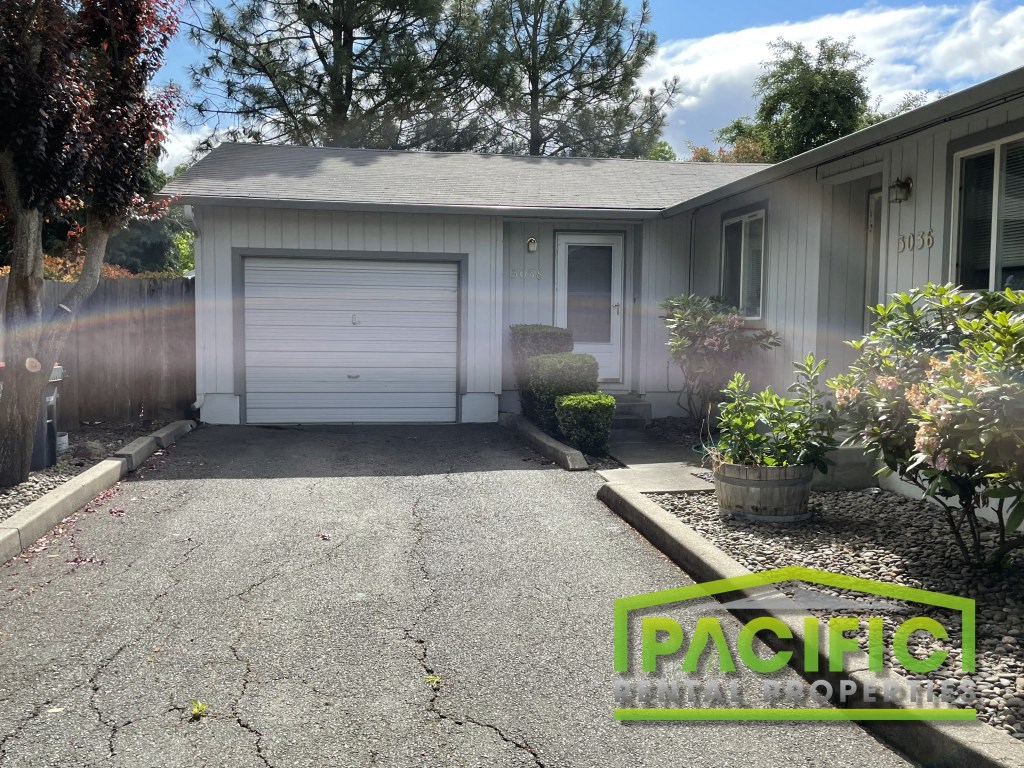 a driveway in front of a house with a white garage door