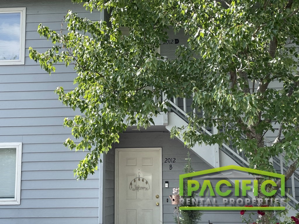a pacific rental property sign in front of a house