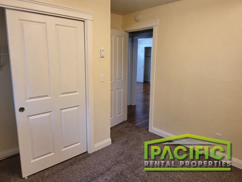 a bedroom with a closet and a door to a hallway