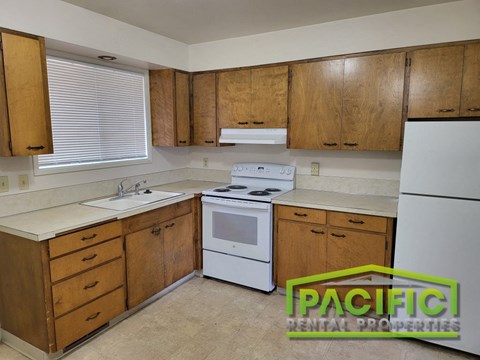 a small kitchen with white appliances and wooden cabinets