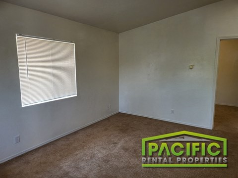 an empty living room with white walls and a window