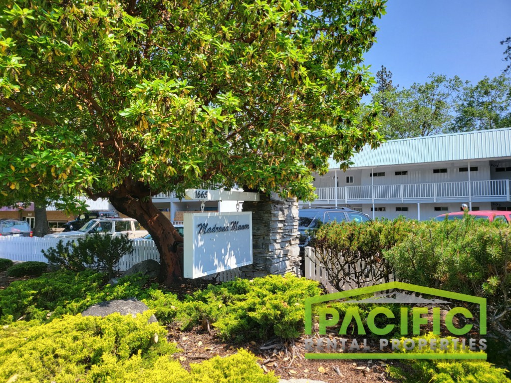 a building with a sign in front of a tree
